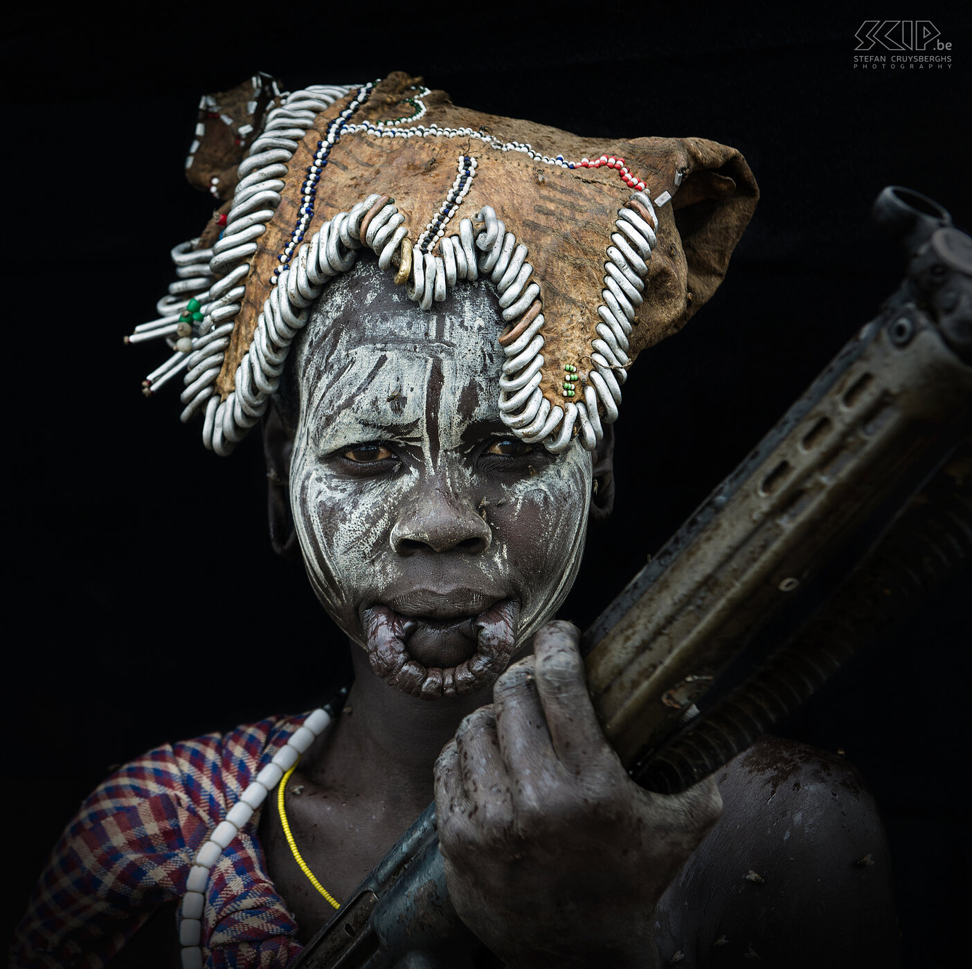 Mago - Mursi vrouw met geweer Een Mursi vrouw met beschilderd gezicht en een doorboorde lip (voor een lipschotel) en met een oud HK G3 geweer. De Mursi leven nog heel traditioneel en kennen bijna geen moderne voorwerpen, maar zoals je kan zien lopen ze soms wel met moderne wapens rond, een groot contrast. Stefan Cruysberghs